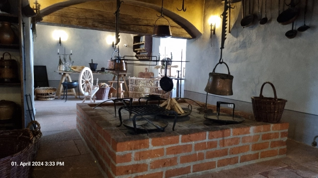 Schwarzküche mit gemauertem Kamin und Töpfen darüber