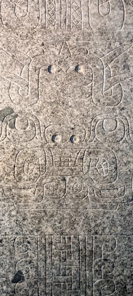 Ansicht der Stele mit Attributen von Schlangen, Katzenkiefern und Vogelkrallen